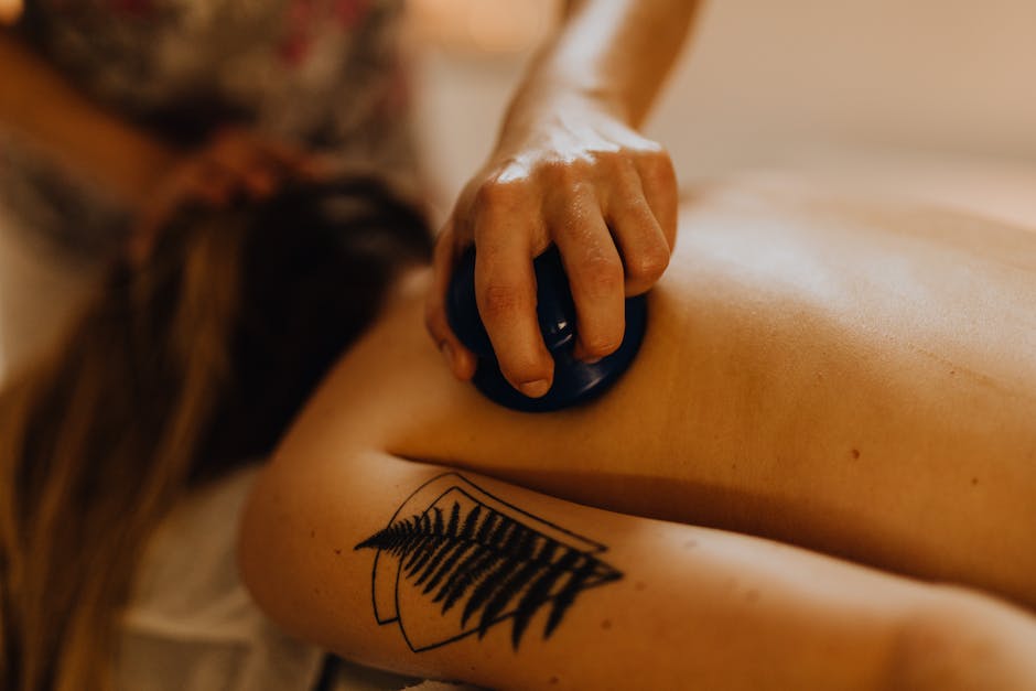 Image of a person receiving an abdominal massage with their hands on their stomach, visualizing the techniques described in the text.