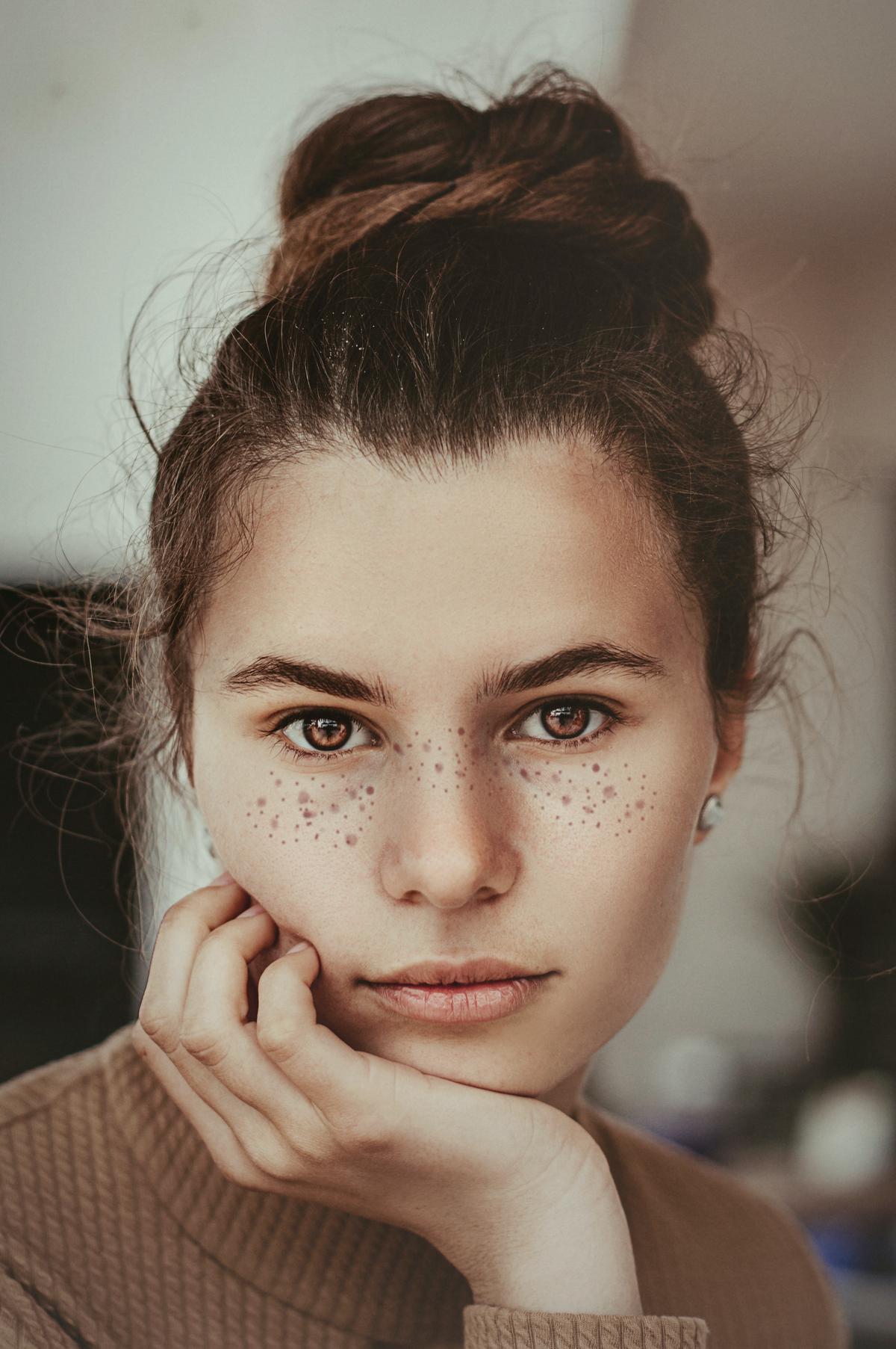 Image of a woman applying castor oil on her face for skin care