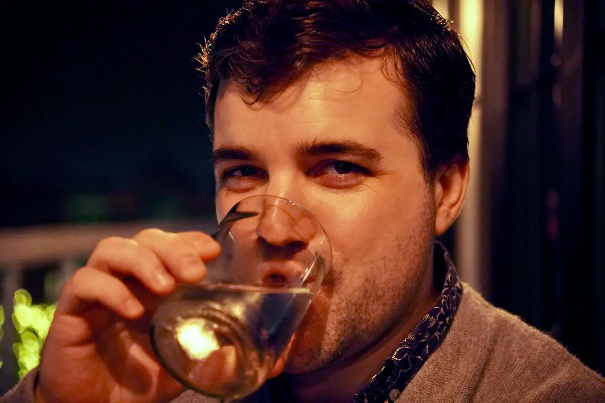 An image of a person drinking water from a glass. The image represents the importance of hydration for overall health.