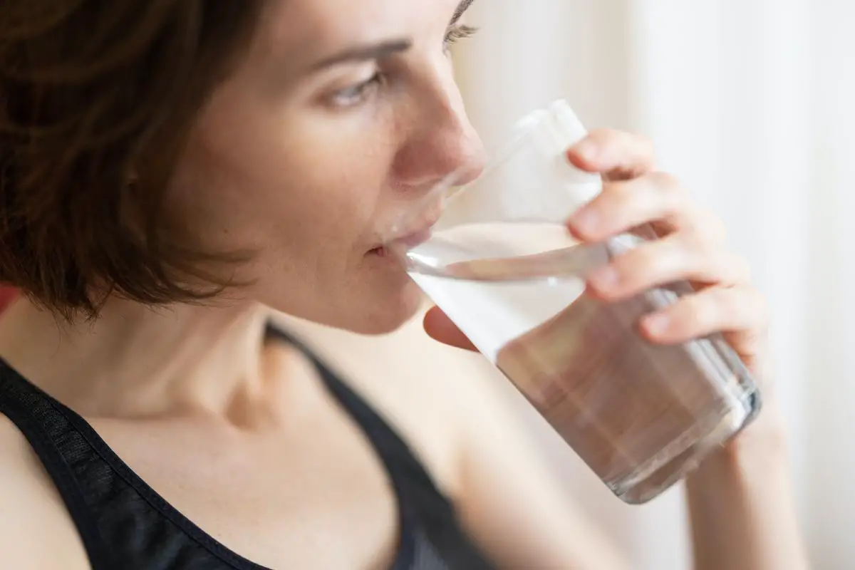 Image depicting a pregnant woman drinking water to prevent dehydration during pregnancy