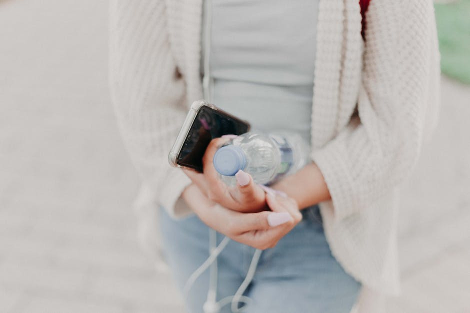 Image of a person holding a water bottle and drinking water