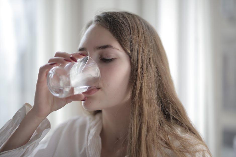 Image of a person drinking water from a glass, emphasizing the importance of hydration.