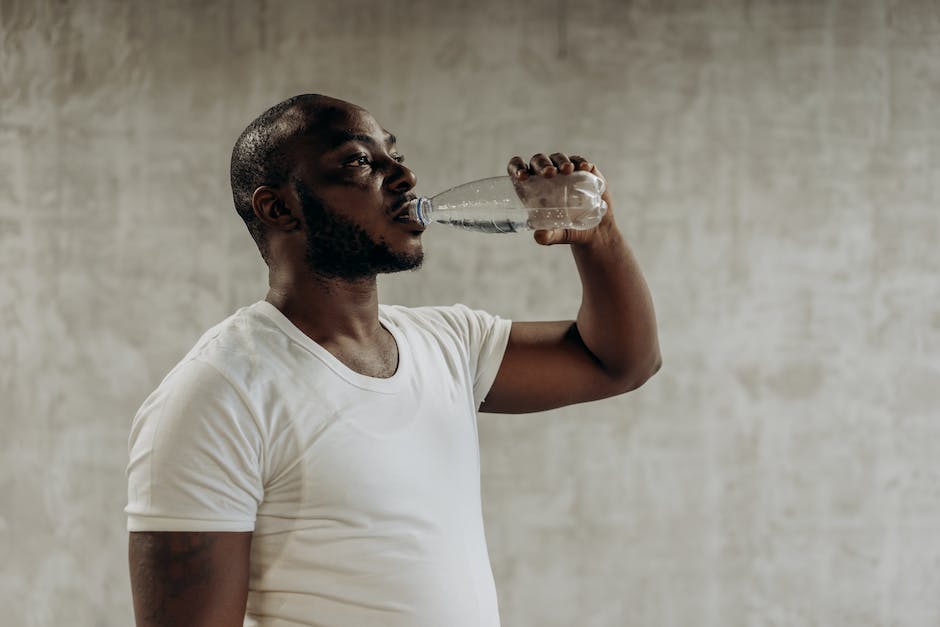 A person drinking water from a bottle while exercising