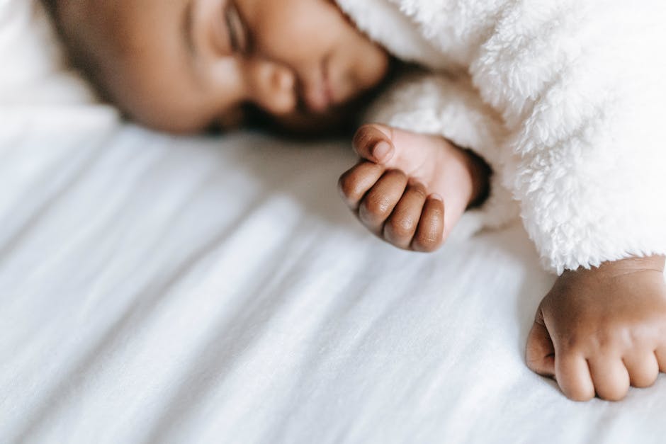 A caregiver gently massaging an infant's belly