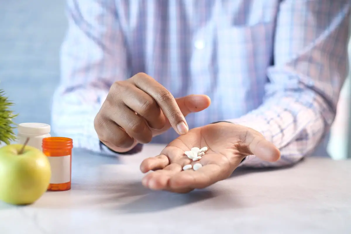 A person holding a bottle of medication with the label 'Interstitial Cystitis Medication'