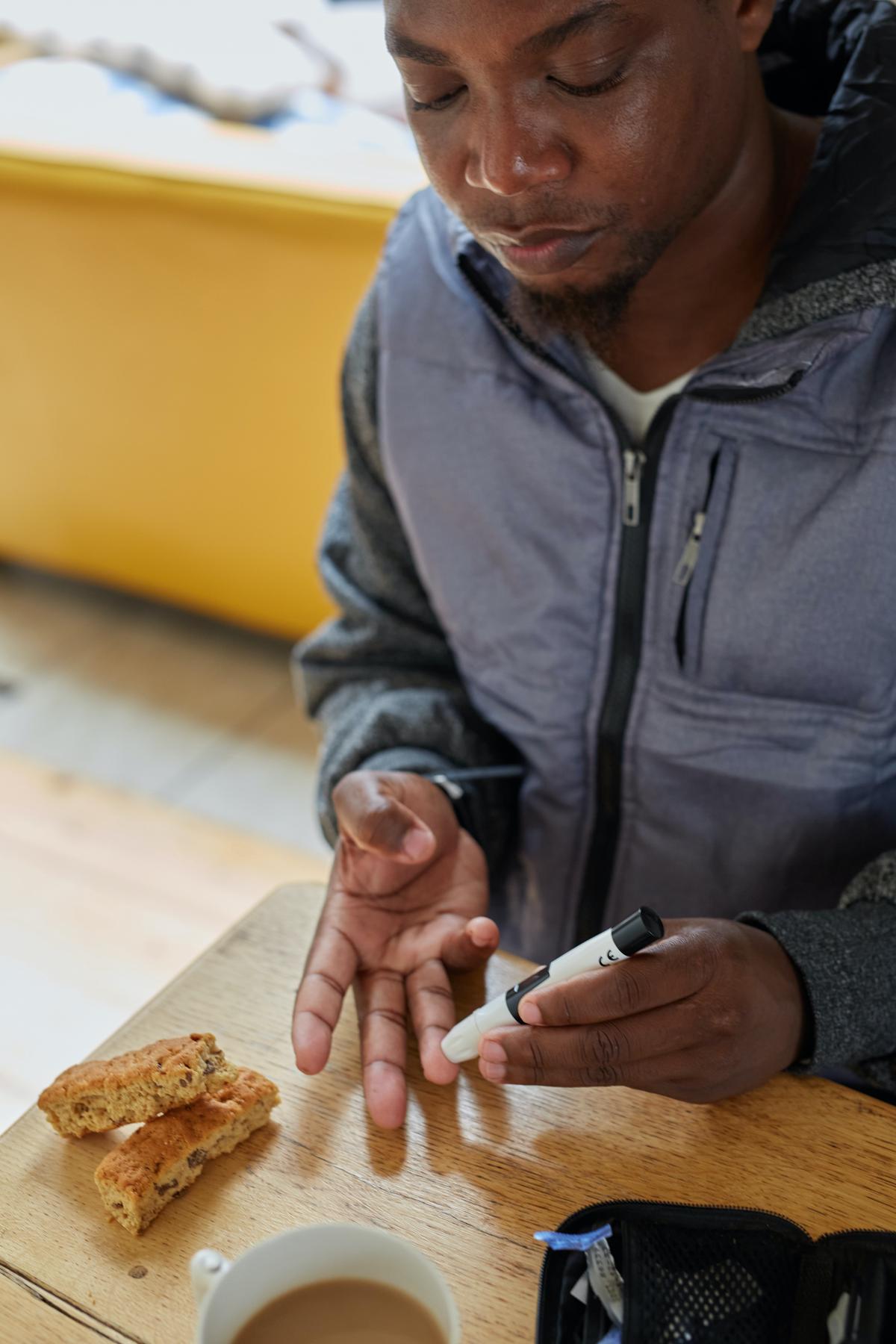 Image depicting a person measuring their blood sugar levels with a glucose meter.