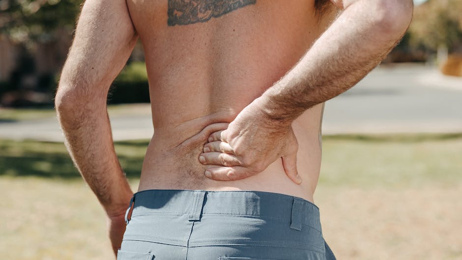 Image of a person holding their lower back in pain