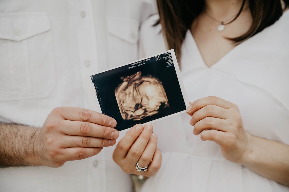 Illustration of a hand holding an ultrasound wand next to a pregnant belly