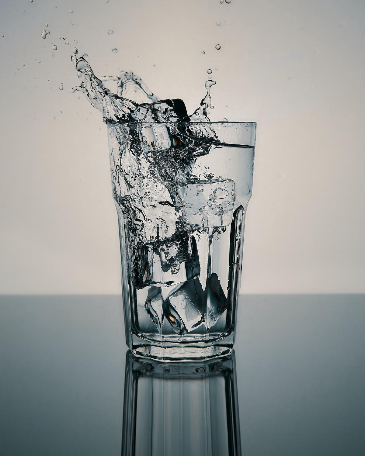 An image showing a person drinking water from a glass.