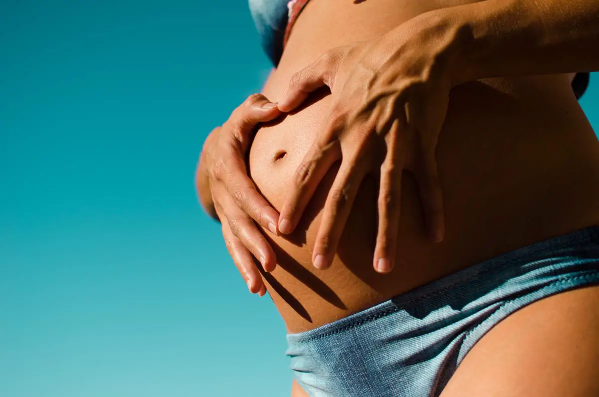 An image depicting a couple holding their bellies together, symbolizing the shared experience of sympathetic pregnancy