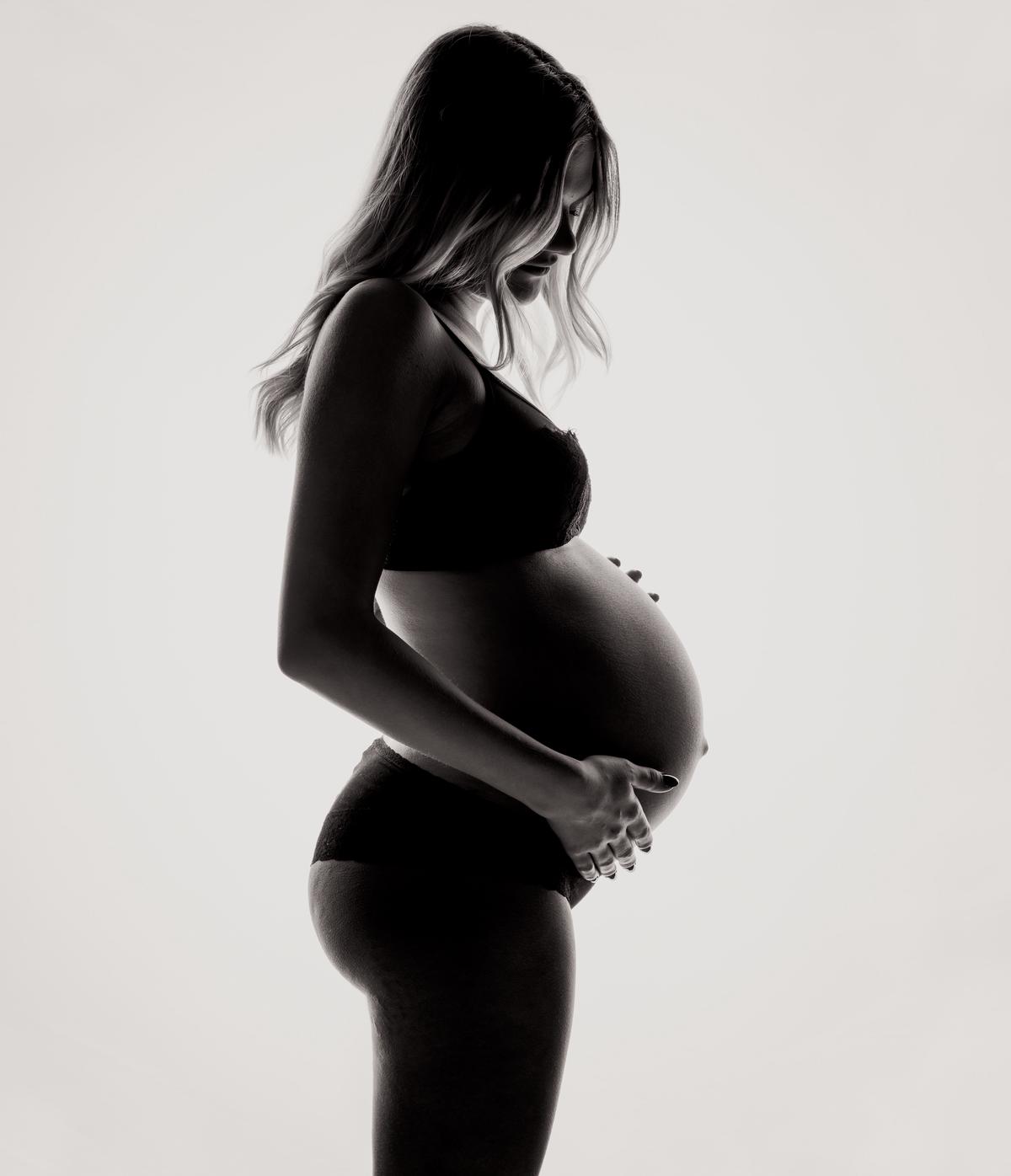 An image illustrating sympathetic pregnancy, with a couple holding hands and a thought bubble with pregnancy-related symbols above the man's head.